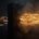 Bundle of amber light streaks hurled at high speed against a dark stone monolith that does not move an inch, the streaks bursting into sparks against its face while a few pass beyond it into the dark meeting nothing
