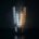 Candela di vetro spaccata a metà che rivela dentro di sé una scala di celle luminose, azzurre da un lato e ambra dall'altro, concetto di candela bid/ask