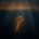 An antique golden key hanging as bait from a steel fishing hook, suspended in dark water with amber light filtering down from the surface.